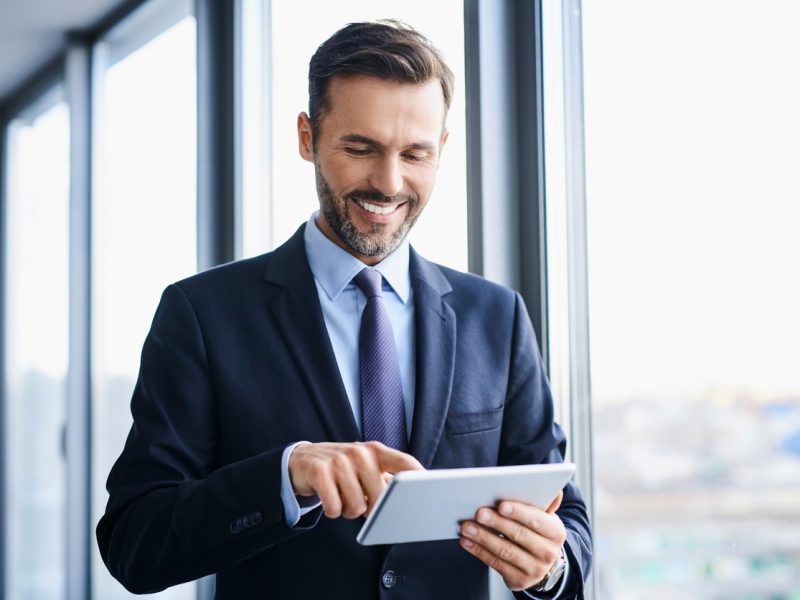 Confident executive reviewing career options on a digital tablet